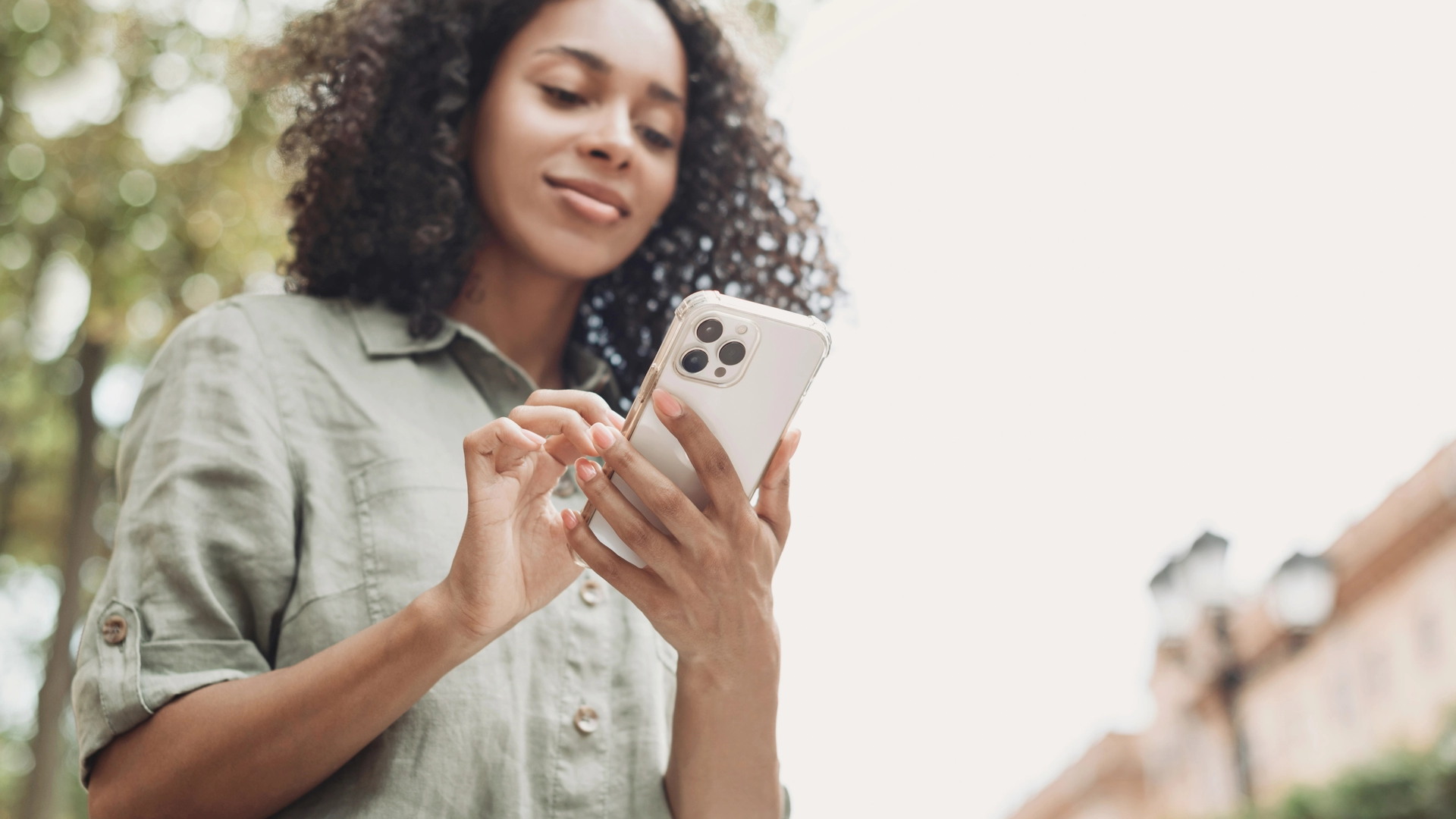 Woman holding a phone wearing a gray sweater